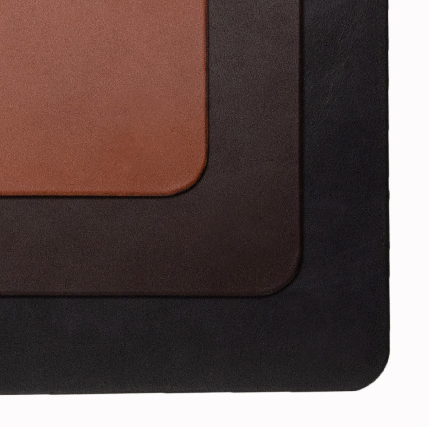 Three leather samples in brown, black, and a reddish-brown color on a white background.